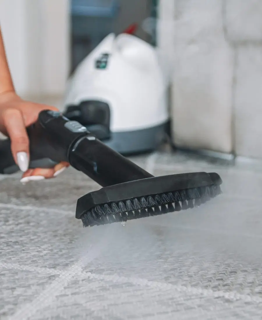 Mulher limpando carpete com um limpador a vapor